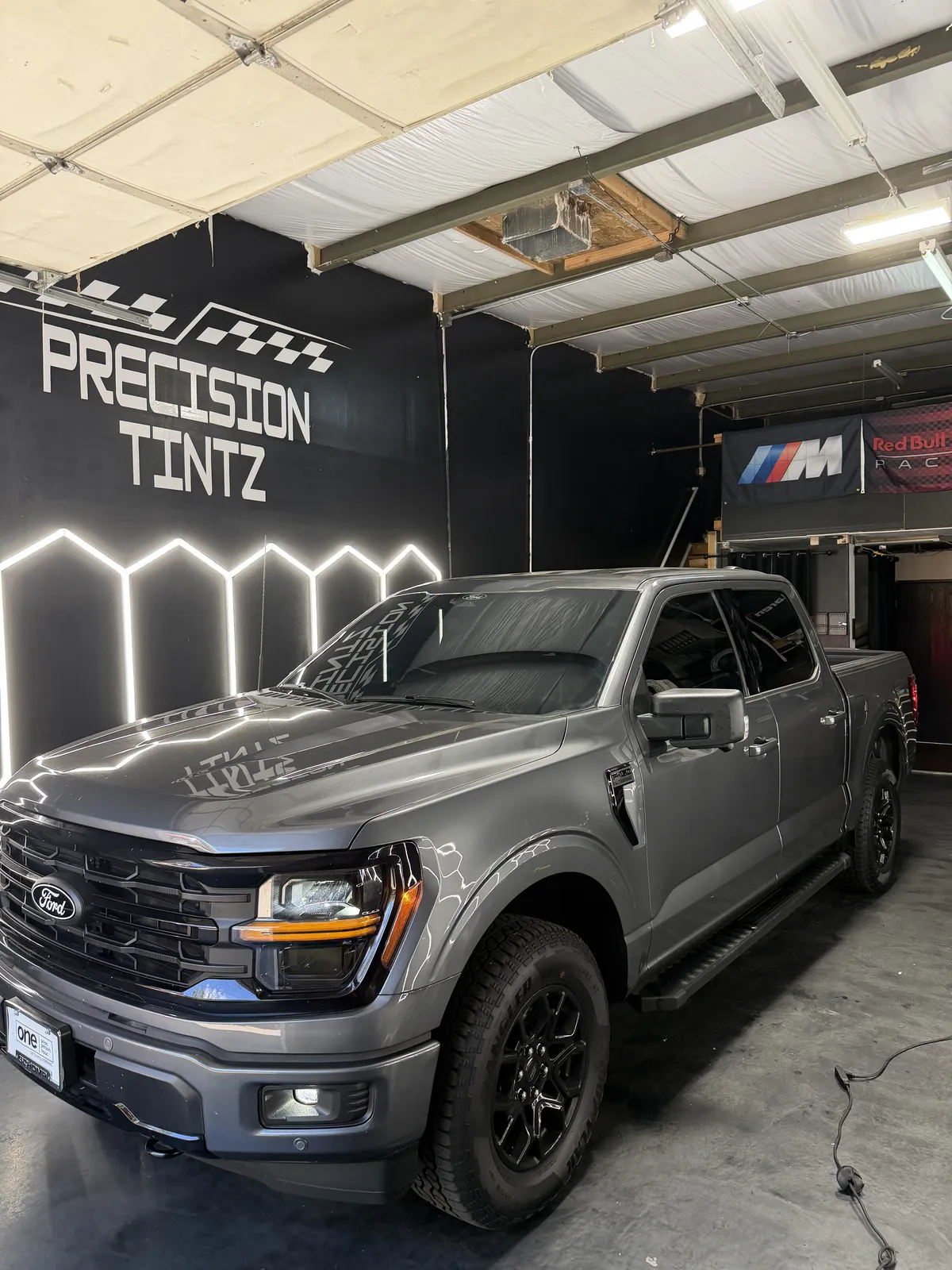 Grey Ford F-150 with a deep gloss finish inside the Precision Tintz bay