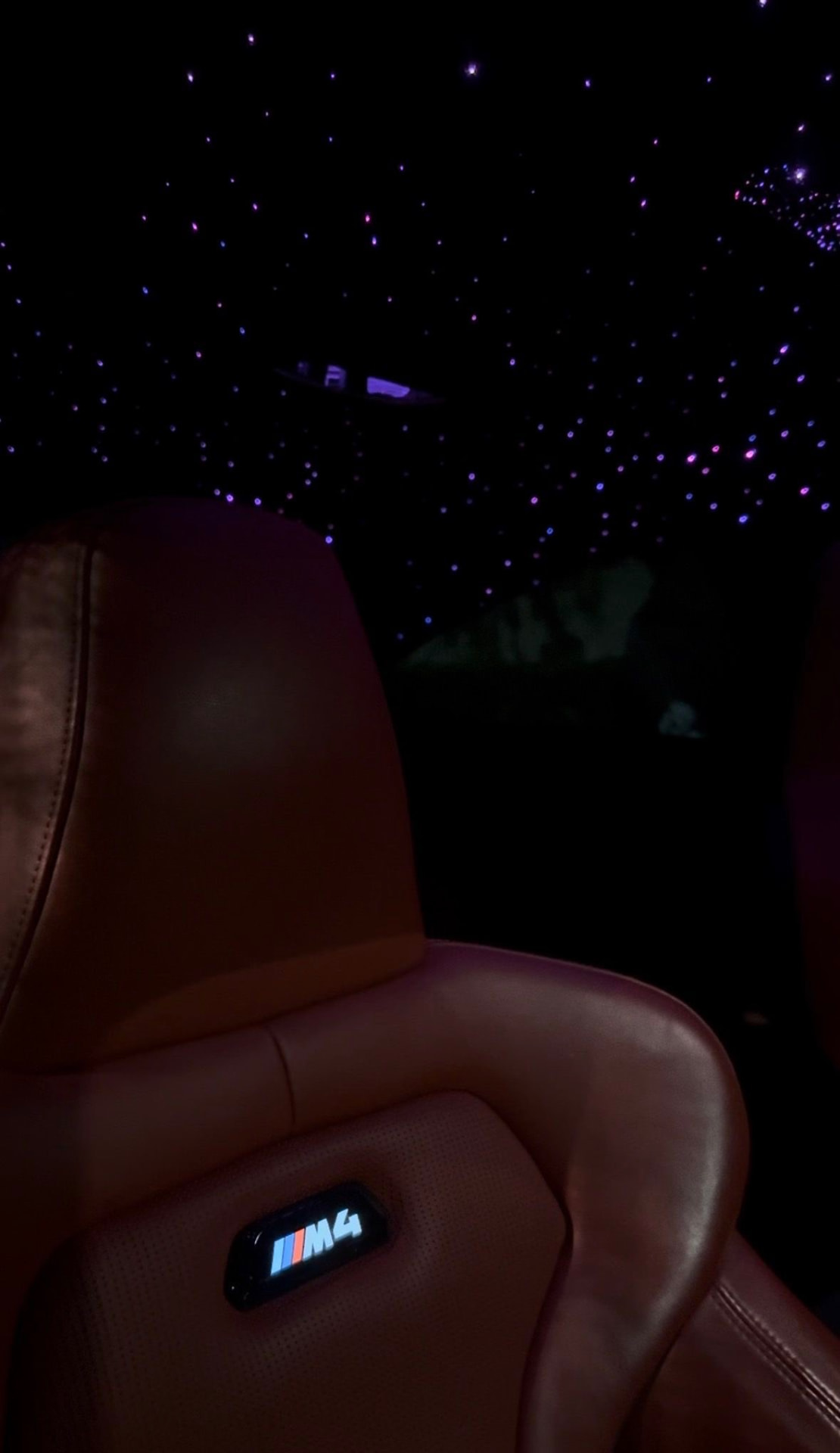 BMW M4 interior at night with a fiber-optic starlight headliner installed by Precision Tintz