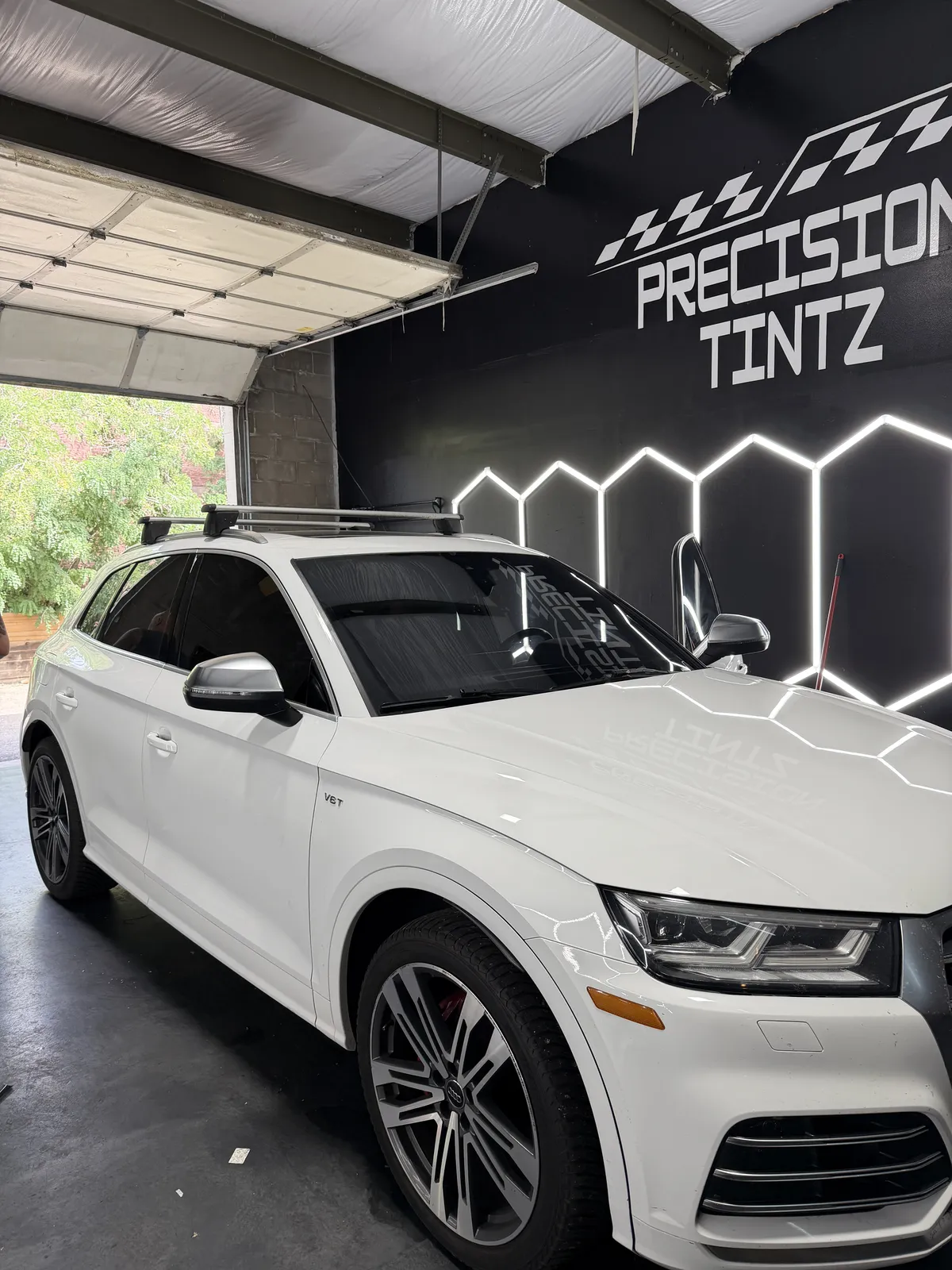 White Audi SQ5 after a full window tint install under the Precision Tintz hex lights