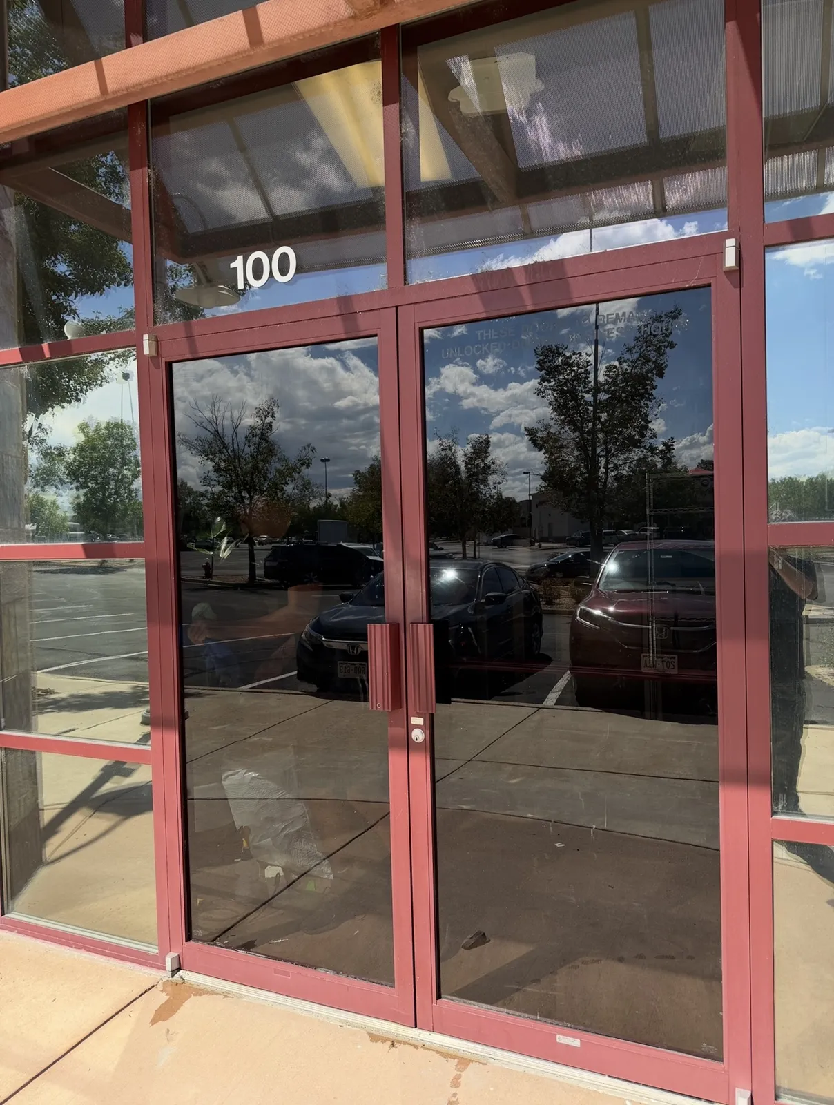 Tinted glass entry doors on a commercial suite after window film installation